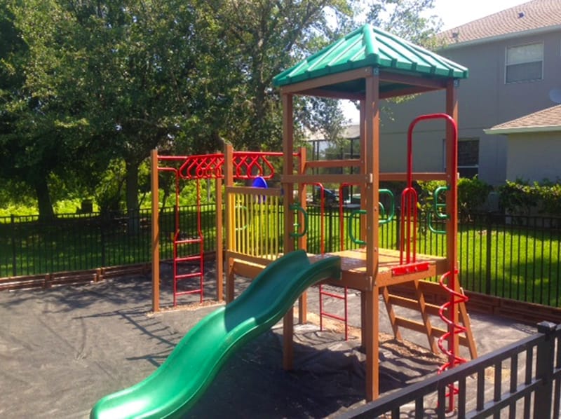 image of small community playground equipment, slide and monkey bars