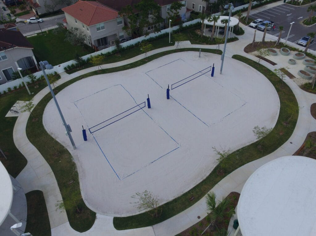 aerial image of sand volleyball court with grass surrounding border