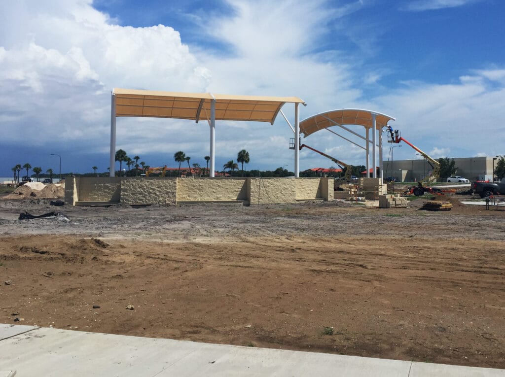 image of shade structure installation, cleared land and erecting structure with cranes