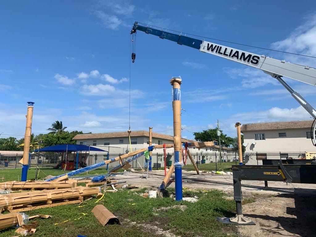 image of crane preparing to lift frame of shade structure frame during assembly