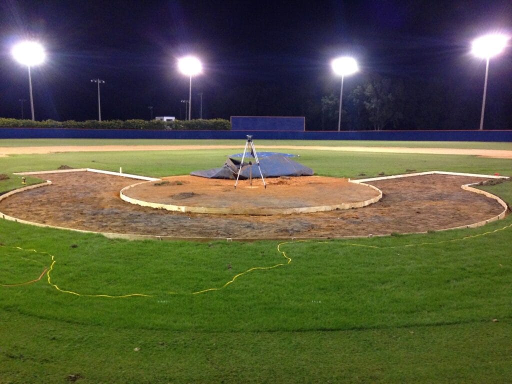 layout in ground, built of wood, for turf halo in field, night time with lights