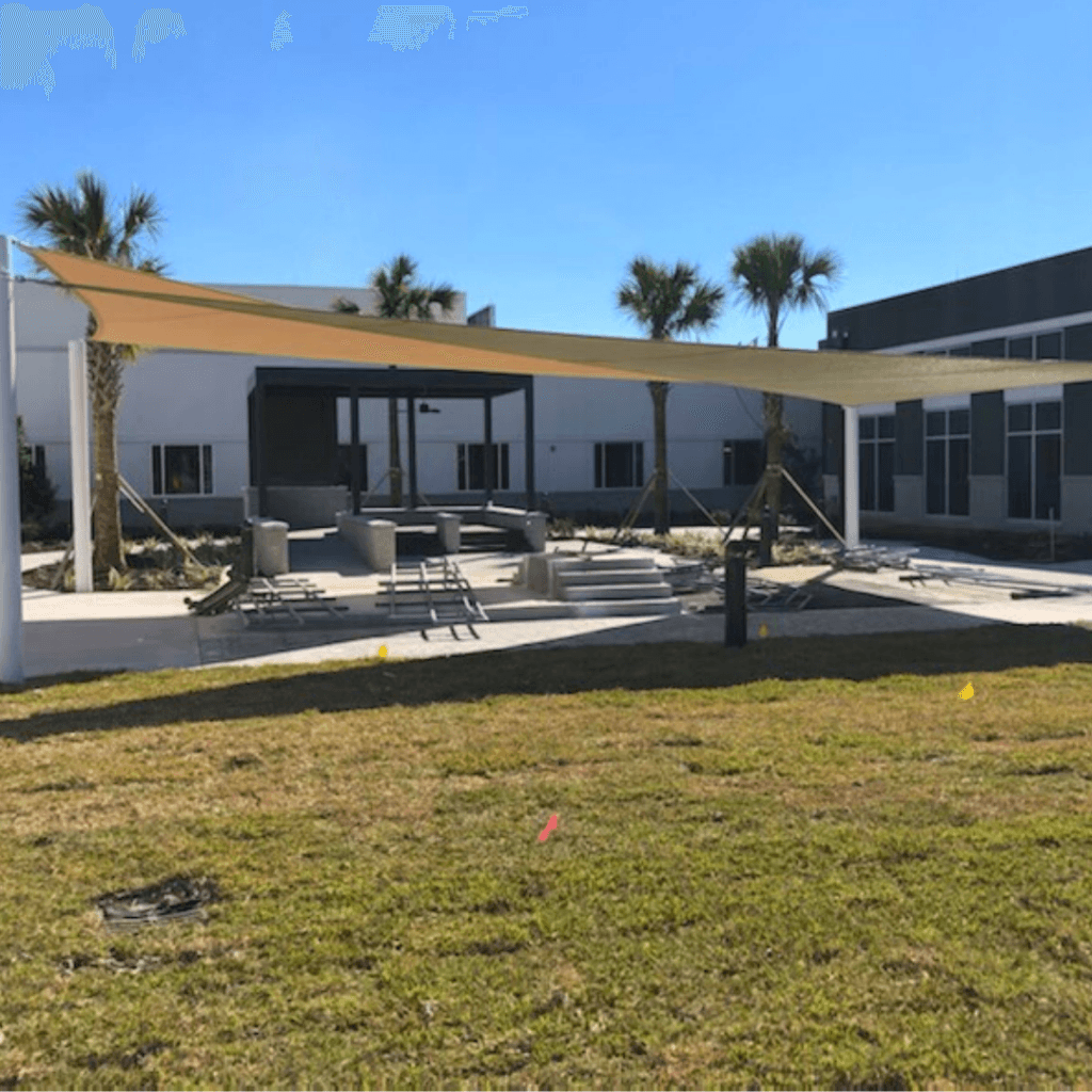 Two completed triangle shade structures over courtyard.