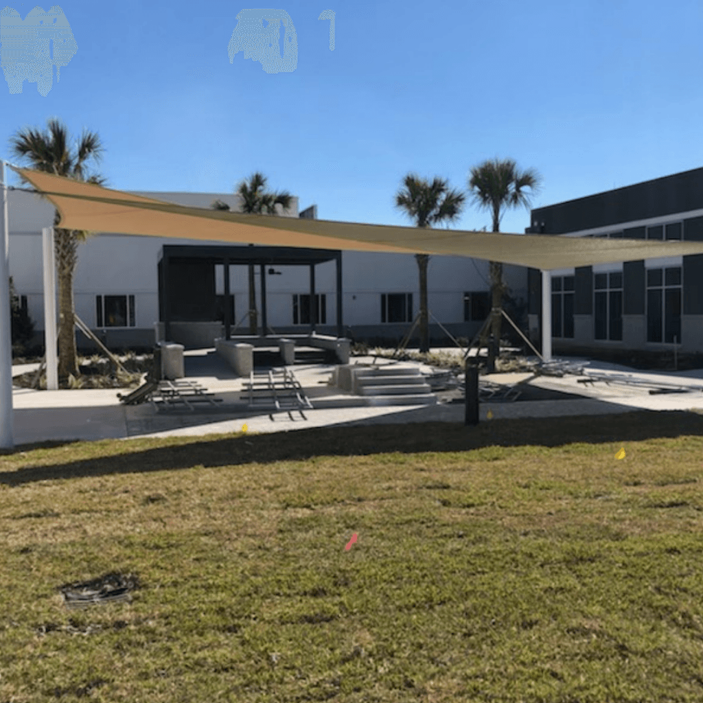 Two completed triangle shade structures over courtyard.